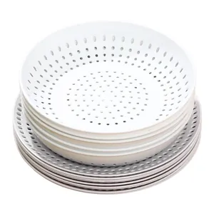 Stack of white perforated plastic draining plates for kitchen use and steaming