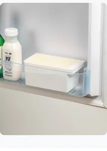 Recipiente blanco para mantequilla guardado en el estante lateral de la nevera