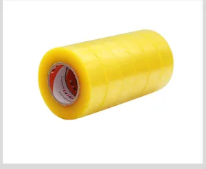 Primo piano di più rotoli di nastro da imballaggio giallo spesso e trasparente per posta.