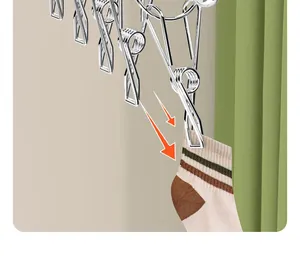Close-up of stainless steel drying rack clip holding a striped cotton sock.