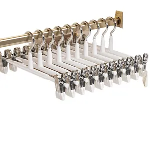 Set of white non-slip pants hangers with adjustable silver clips for closet storage
