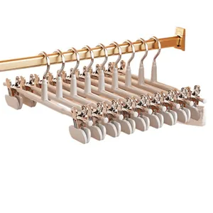 Lot de cintres à pantalons antidérapants crème avec pinces métalliques sur barre dorée