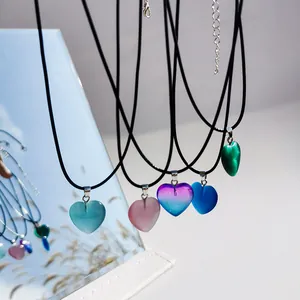 Dettaglio di ciondoli a forma di cuore colorati su cordini neri regolabili per le donne