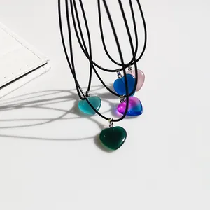 Dettaglio di vivaci ciondoli a forma di cuore colorato su corde nere eleganti
