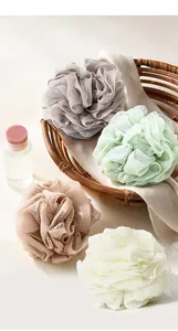 Detail view showing the soft mesh texture of colorful bath loofah sponges in a basket
