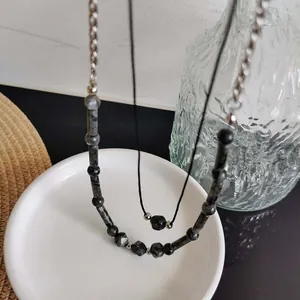 Dettaglio collana fatta a mano in pietre naturali con catena argento e cordino nero