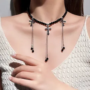 Elegant black beaded choker necklace with cross pendants and dangling chains for women.