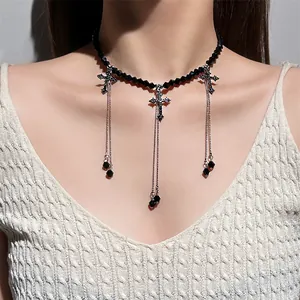 Close-up detail of a gothic black beaded choker featuring dangling silver cross pendants