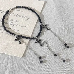 Close-up of black beaded choker necklace featuring three gothic cross pendants and chains