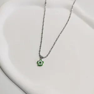 Gedetailleerde weergave van een groen-witte madeliefjesketting op een wit dienblad
