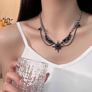 Detail of gothic punk necklace featuring black wings and star pendant on model neck