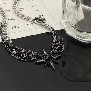Detailed close-up of dark gothic wing and star pendant necklace in Y2K punk aesthetic.