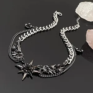 Detailed macro shot of dark Y2K gothic wing and star necklace with black gemstones and double chains
