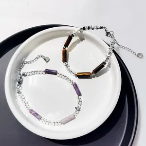 Gros plan de bracelets en perles d'argent avec pierres naturelles d'œil de tigre et améthyste