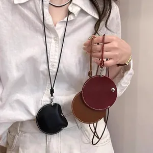 Primo piano di eleganti astucci da collo in pelle per auricolari o chiavi su una modella