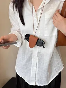 Dettaglio ravvicinato di una collana portaocchiali magnetica in pelle marrone da donna