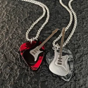Primo piano dettagliato di collane con ciondolo a forma di chitarra e plettro
