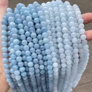 Gros plan de perles rondes en calcédoine aigue-marine bleu clair pour la création de bijoux.