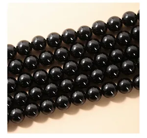 Détail en gros plan de perles rondes en obsidienne noire naturelle pour bijoux DIY.