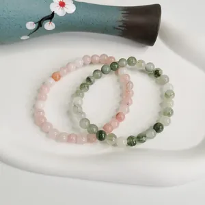 Primo piano di braccialetti di perle in cristallo naturale e agata da 6mm su vassoio.