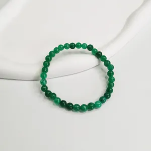 Dettaglio bracciale con perle di agata verde naturale da 6mm su vassoio bianco.