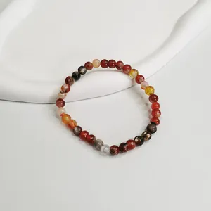 Dettaglio in primo piano del bracciale elastico in agata rossa da 6 mm su vassoio