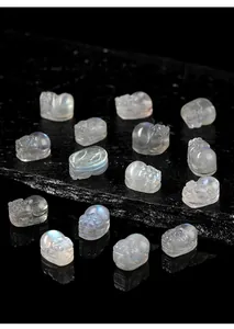 Close-up of translucent grey moonstone Pixiu carvings with vibrant blue flash effect
