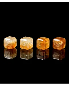 Detailopname van vier gefacetteerde natuurlijke citrien kubuskralen voor DIY-sieraden maken