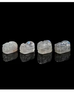 Macro detail of ice-clear gray moonstone Pixiu carvings showing vibrant blue labradorescence
