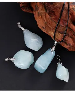Gros plan de pendentifs en aigue-marine bleue naturelle irrégulière avec bélières argent