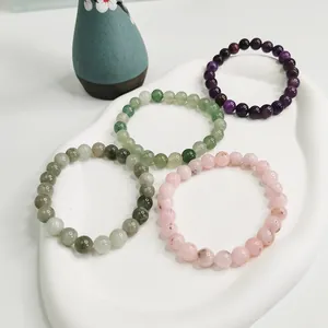 Detailansicht von 8mm Naturkristallperlen-Armbändern in violetten, grünen und rosa Tönen