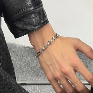 Detailed view of a silver titanium steel knotted link chain bracelet on a man's wrist