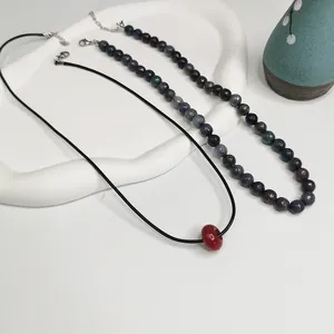 Gros plan d'un collier en pierres naturelles et d'un pendentif en cordon minimaliste