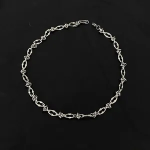 Detailed view of a silver titanium steel necklace featuring a unique barbed wire link design