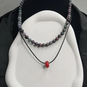 Collier de style chinois minimaliste avec perles en pierre naturelle et pendentif rouge.
