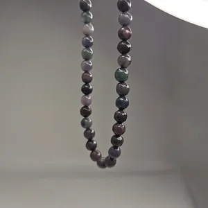 Gros plan des perles en pierre naturelle facettées sur un collier de style néo-chinois