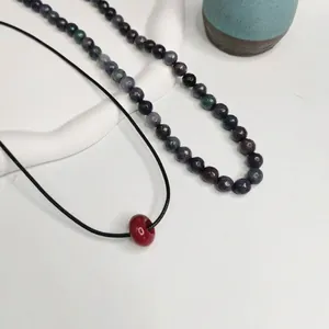 Collier artisanal en pierres naturelles de style chinois avec cordon noir et pendentif rouge
