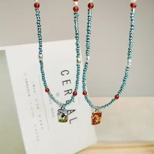 Detailaufnahme von handgefertigten Perlenketten mit chinesischen Emaille-Anhängern.
