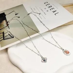 Detailed view of retro floral and oval pendants on silver pearl accented necklaces