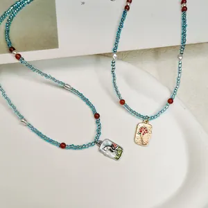 Detailansicht der handgefertigten blauen Perlenkette mit Vintage-Rosen-Anhängern