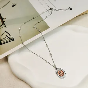 Close-up of vintage enamel floral pendant necklace with delicate pearl chain