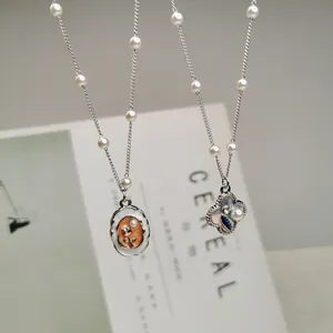 Close-up detail of vintage style enamel flower pendants with elegant pearl chain accents
