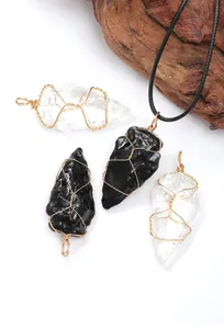 Macro view of handmade wire-wrapped natural crystal and obsidian arrowhead pendants