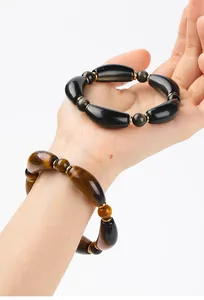 Detail of natural yellow tiger eye and golden obsidian curved tube bead bracelets