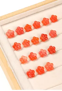 Close-up of red agate flower carved beads arranged in a jewelry tray