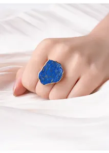 Gedetailleerde close-up van een vergulde ring met natuurlijke blauwe ruwe steen