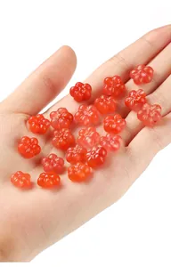 Close-up of red carved flower beads held in hand showing intricate details for DIY jewelry
