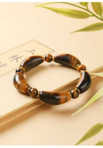 Close-up of natural tiger eye bracelet with polished curved tube and round beads