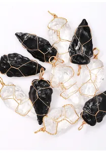 Close-up detail of handcrafted wire wrapped arrowhead crystal and obsidian pendants