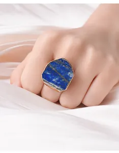 Detailopname van een verstelbare ring met natuurlijke blauwe steen en gouden rand